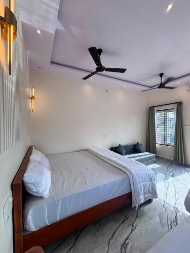 a bedroom with a bed with a ceiling fan at Hampi Tribes Homestay in Hampi