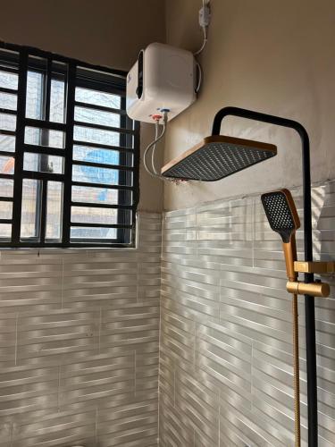 a room with a shower with a window at Vn mbeya apartment in Mbeya