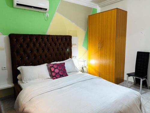 a bedroom with a large bed with a pillow on it at Immeuble paco in Douala