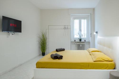 a bedroom with a yellow bed with a flat screen tv at RELAX APARTMENT in the Mountains in Valdieri