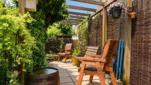 a patio with chairs and a table and an umbrella at Suncroft in Shotteswell