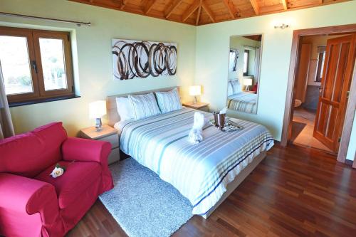 a bedroom with a large bed and a red couch at Casa Vista Mar in Tijarafe