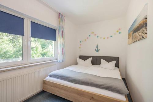 a bedroom with a bed and two windows at Ferienwohnung Emily in Garz
