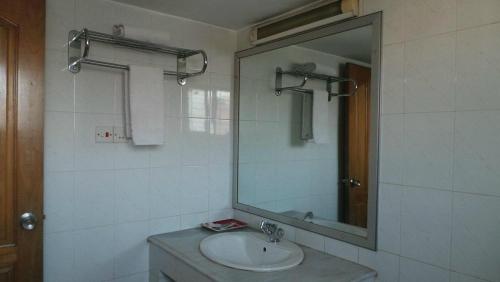 a bathroom with a sink and a mirror at Hotel Aristos Boutique & Suites in Chittagong