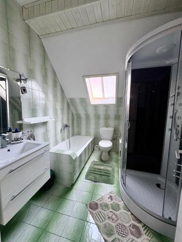 a bathroom with a tub and a toilet and a sink at Oli vendégház in Balatonboglár