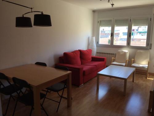 a living room with a red couch and a table at Homing Mollerussa 13 in Mollerussa