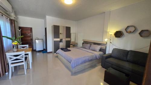 a bedroom with a bed and a couch and a table at Samati Best House - Pool Apartments A1 - Klong Ning Beach in Ko Lanta Yai