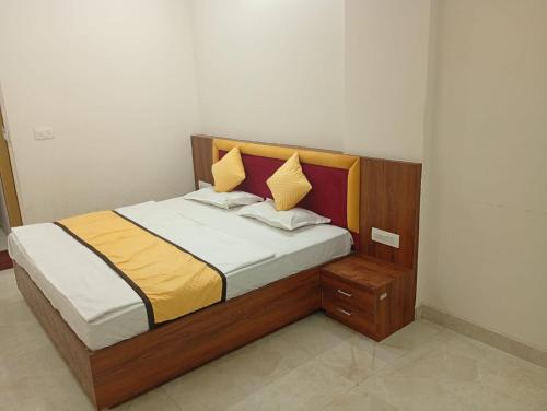 a bedroom with a large bed with a wooden headboard at Hotel Vijay Palace in Agra