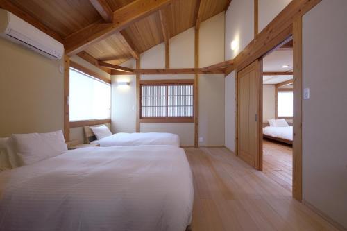 two beds in a room with wooden floors at 刀都の郷 清川 in Sekimachi
