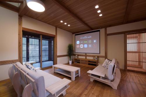 a living room with a large screen in a room at 刀都の郷 清川 in Sekimachi