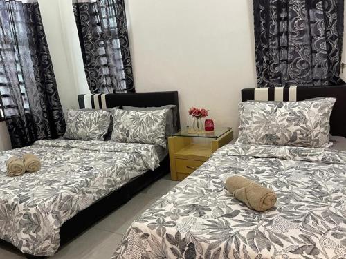 a bedroom with two beds and a night stand with a bedskirts at RUANG by ZD in Pekan