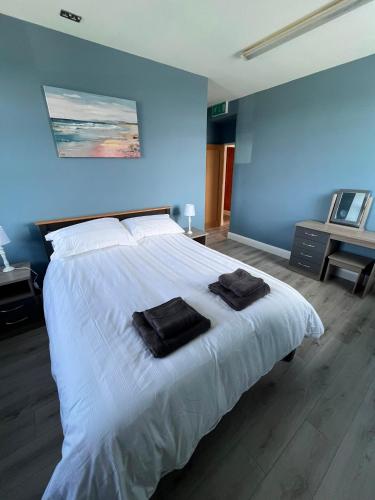 a bedroom with a white bed with two towels on it at Clohanbeg School House in Kilrush
