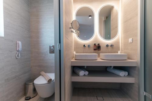 a bathroom with two sinks and a mirror at Kefalos View in Vrachonisída Palaiókastro