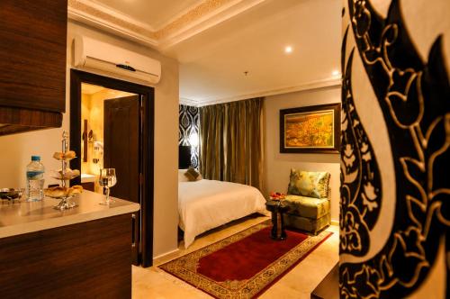 Palais Riad Reda & Spa في فاس: غرفة فندق بها غرفة نوم بها سرير وكرسي