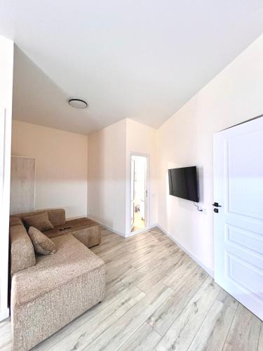 a living room with a couch and a flat screen tv at Hayrapetyan Guest House in Yeghegnadzor