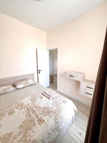 a white bedroom with a bed and a door at Hayrapetyan Guest House in Yeghegnadzor
