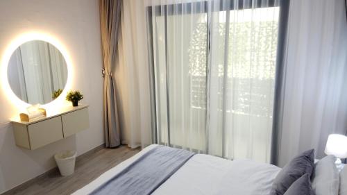 a bedroom with a bed and a mirror and a window at Rima Salalah in Salalah