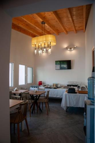 a dining room with tables and chairs and a bed at GLIPTIS Apartments in Chios