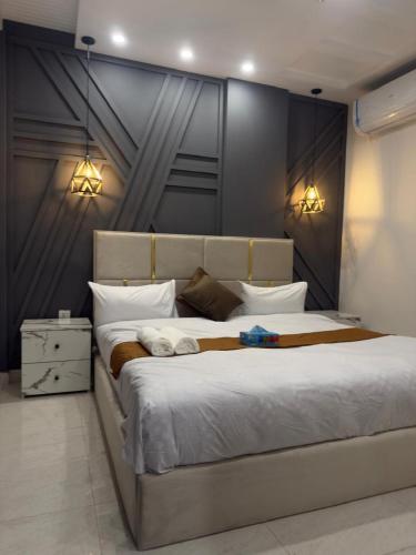 a bedroom with a large bed with two pillows at Royale Rest Suites in Rāmkot