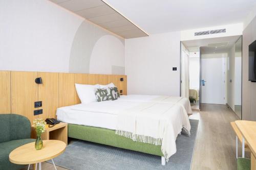 a bedroom with a large bed and a couch at Hotel Garden Istra Plava Laguna in Umag