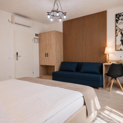 a bedroom with a bed and a blue couch at ARINI WHITE HOUSE in Sibiu