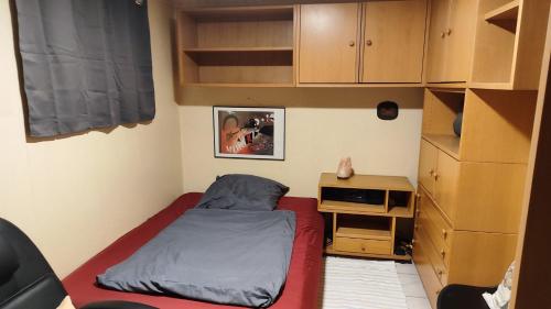 a small bedroom with a bed and a desk at Ferienhaus Ebert, Top-Ausstattung mit Garten, Terrasse & Wall-Box bei Dinkelsbühl in Dinkelsbühl