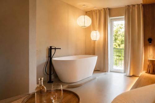 a bath tub in a bathroom with a window at MANA LISA Boutiquehotel in Lauda-Königshofen