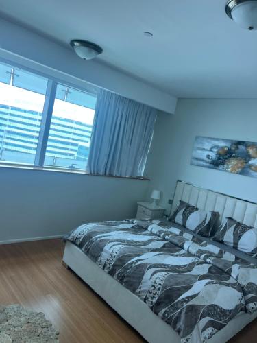 a bedroom with a large bed and two windows at Marina private see view room in Abu Dhabi
