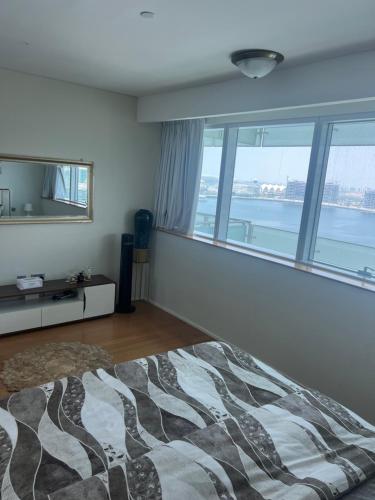 a bedroom with a bed and a large window at Marina private see view room in Abu Dhabi