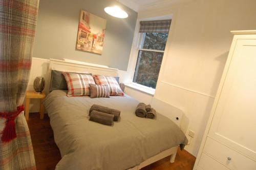 a bedroom with a bed with two towels on it at Baker Street Retreat in Stirling