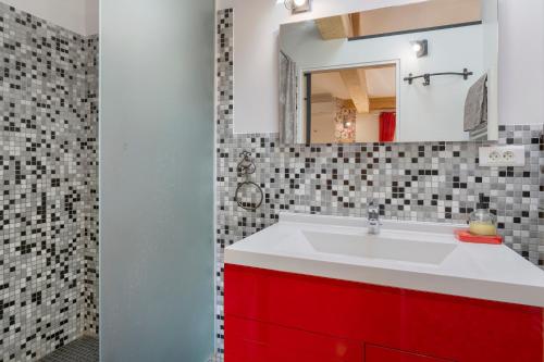 a bathroom with a red sink and a mirror at Chambres D'hôtes Le Cocon in Saint-Paul-les-Fonts