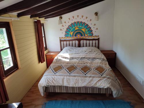 a bedroom with a bed with a rainbow on the wall at Bota Rota Pilgrim House in Paredes de Coura
