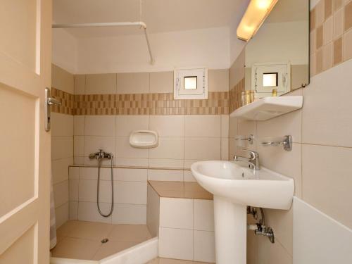 a white bathroom with a sink and a shower at Pension The Flower in Oia