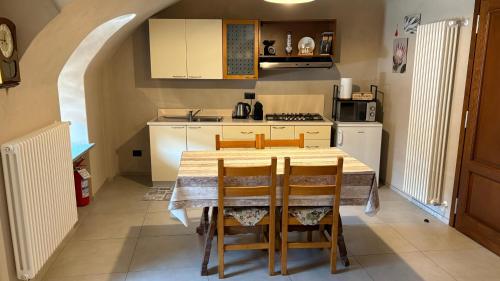 a kitchen with a table and chairs in a room at Il cortile in Boves