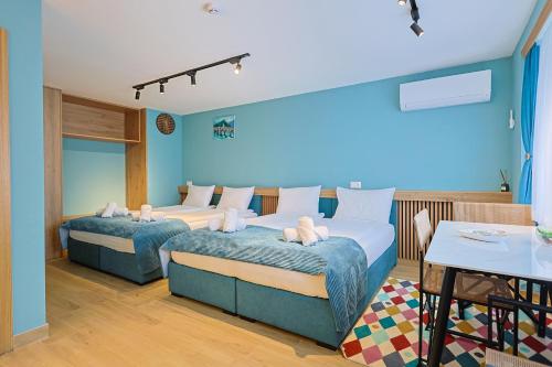 two beds in a room with blue walls at FourMountains-Bjelašnica in Sarajevo