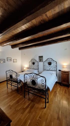 a bedroom with two beds and a wooden floor at Agriturismo Rechsteiner in Ponte di Piave