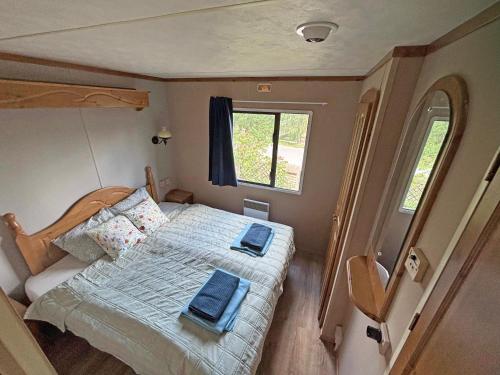 a bedroom with a bed with blue towels on it at Retro Mobilhome in Igal