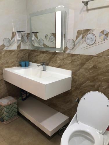 a bathroom with a sink and a toilet and a mirror at Villa SeriGold - NovaWorld Phan Thiết in Tiến Thành