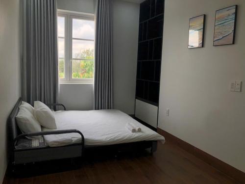a bed in a room with a window at Villa SeriGold - NovaWorld Phan Thiết in Tiến Thành