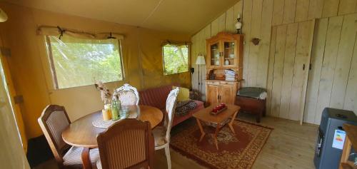 a living room with a table and a couch at Tent Ween at Glamping Verbaarum in Bedum
