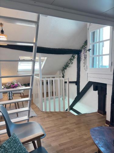 a living room with a ladder and a table and chairs at Duplex Charme & Fleurs, vue Cathédrale in Chartres