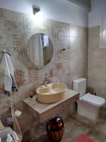 a bathroom with a sink and a mirror and a toilet at Lilly of Lemnos in Roussopoúlion