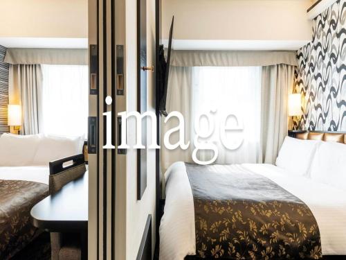 a hotel room with two beds and a table at APA Hotel Osaka Temma in Osaka