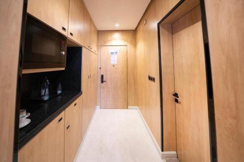a small kitchen with wooden cabinets and a door at Msharef Almoden Hotel in Jazan