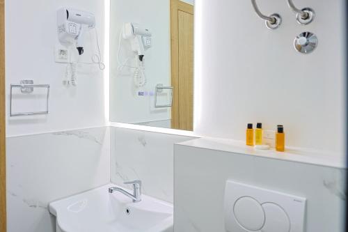 a white bathroom with a sink and a mirror at FourMountains-Bjelašnica in Sarajevo