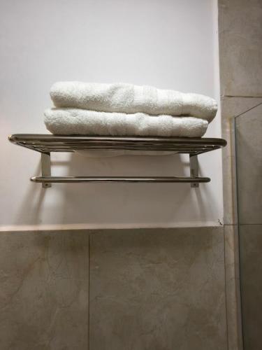 a stack of towels on a shelf in a bathroom at Hotel Boutique Porá Iguazú in Puerto Iguazú