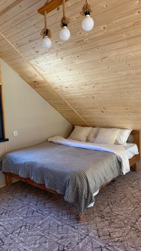 a bed in a room with a wooden ceiling at ALAU villas in Saty
