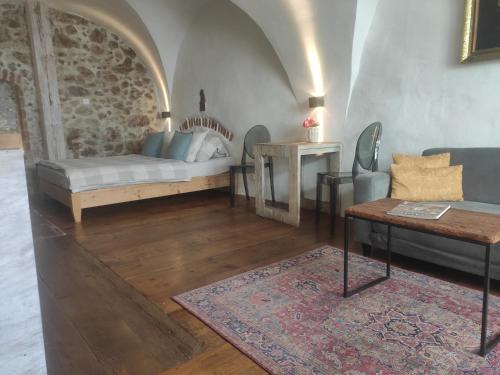 a living room with a bed and a table at Apartmany Antico in Mikulov