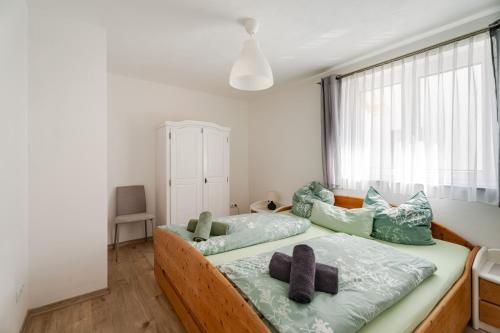 a bedroom with a bed with green pillows and a window at Haus Redi in Sasbach in der Ortenau