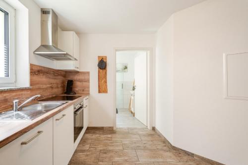 a kitchen with white cabinets and a sink at Haus Redi in Sasbach in der Ortenau